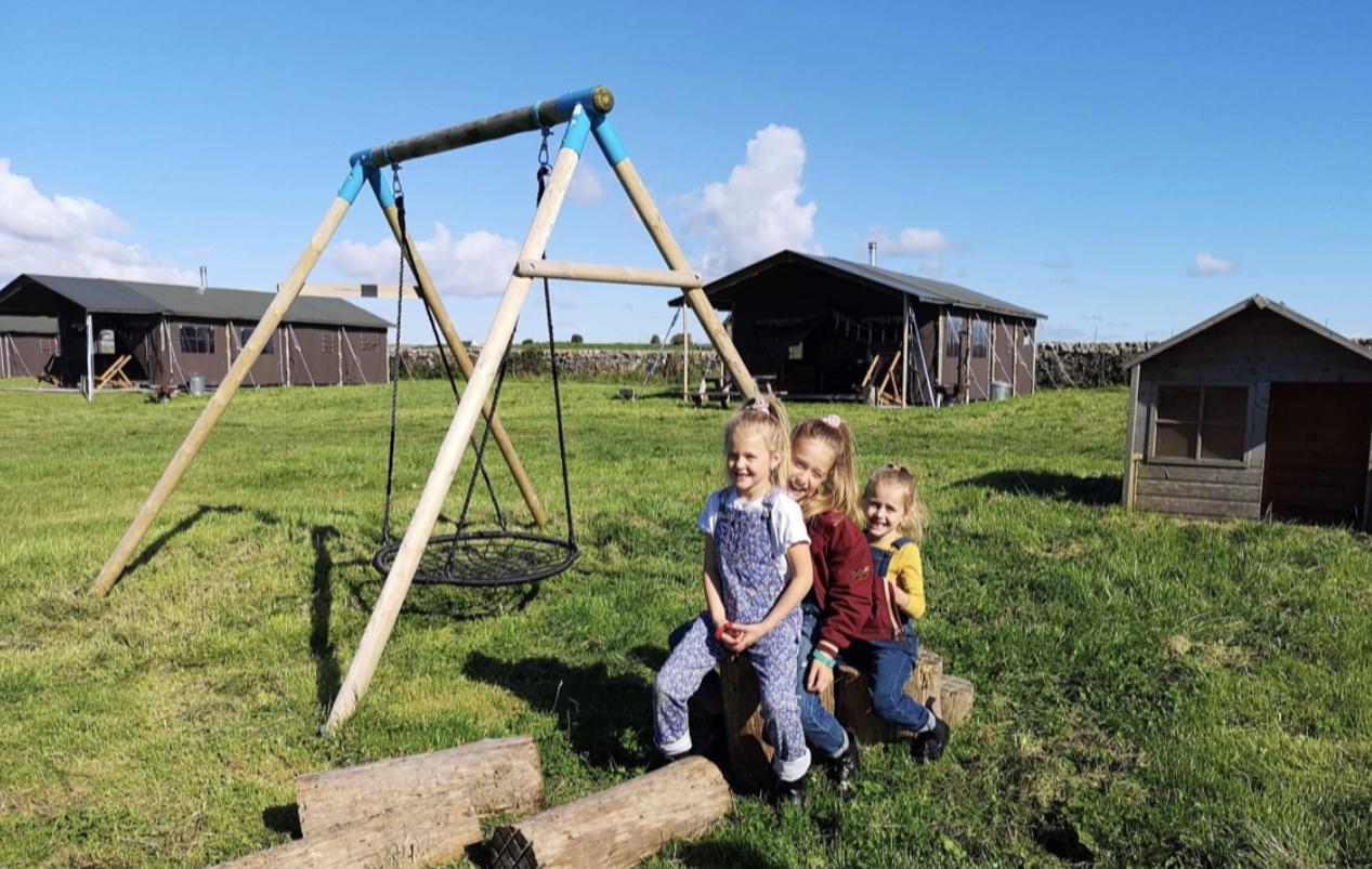 Children playing at Balnab Dairy Farm outside off-grid safari tents